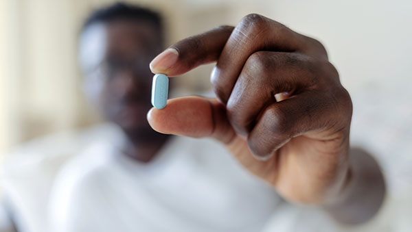 Cropped shot of a young man taking medication at home.